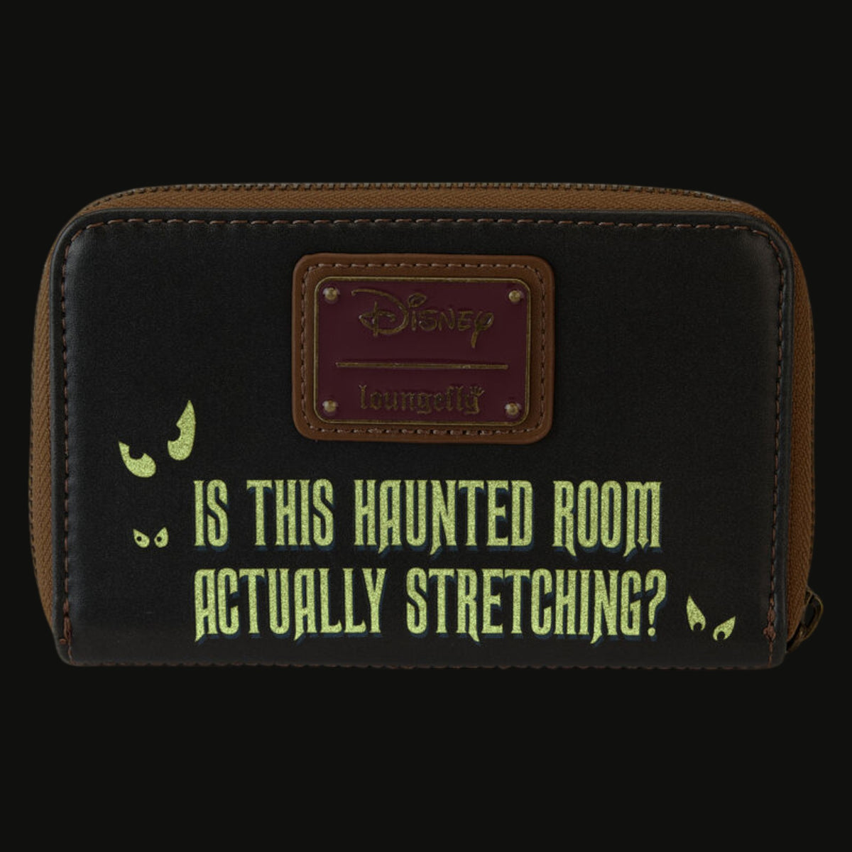 Glowing back of Loungefly Haunted Mansion Stretching Room Portraits wallet with 'Is This Haunted Room Actually Stretching?' yellow text and a Disney Loungefly logo on a white background