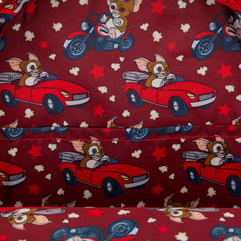 Patterned fabric with Gremlins Gizmo characters in cars on a red background