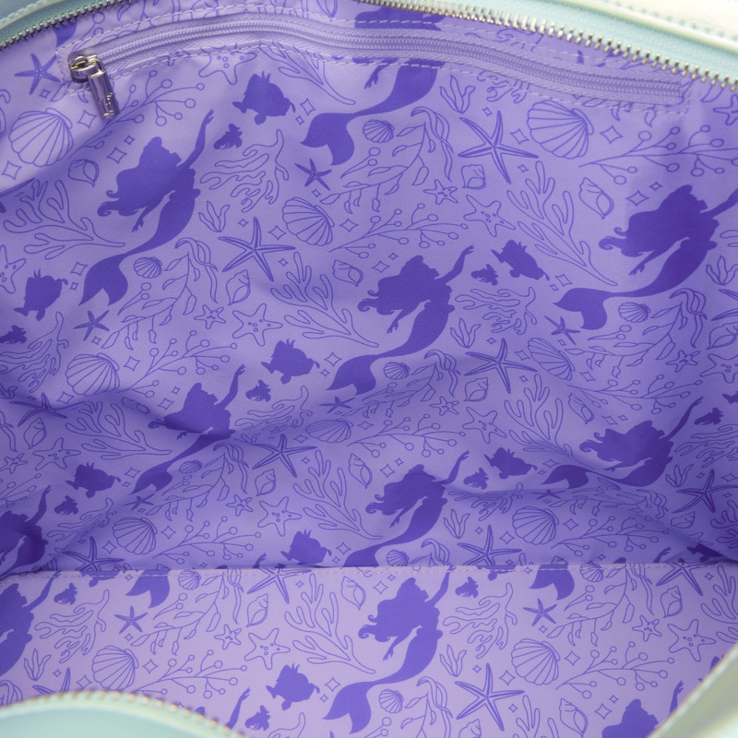 Close-up pf Ariel, starfish, and seashell character pattern on a purple background