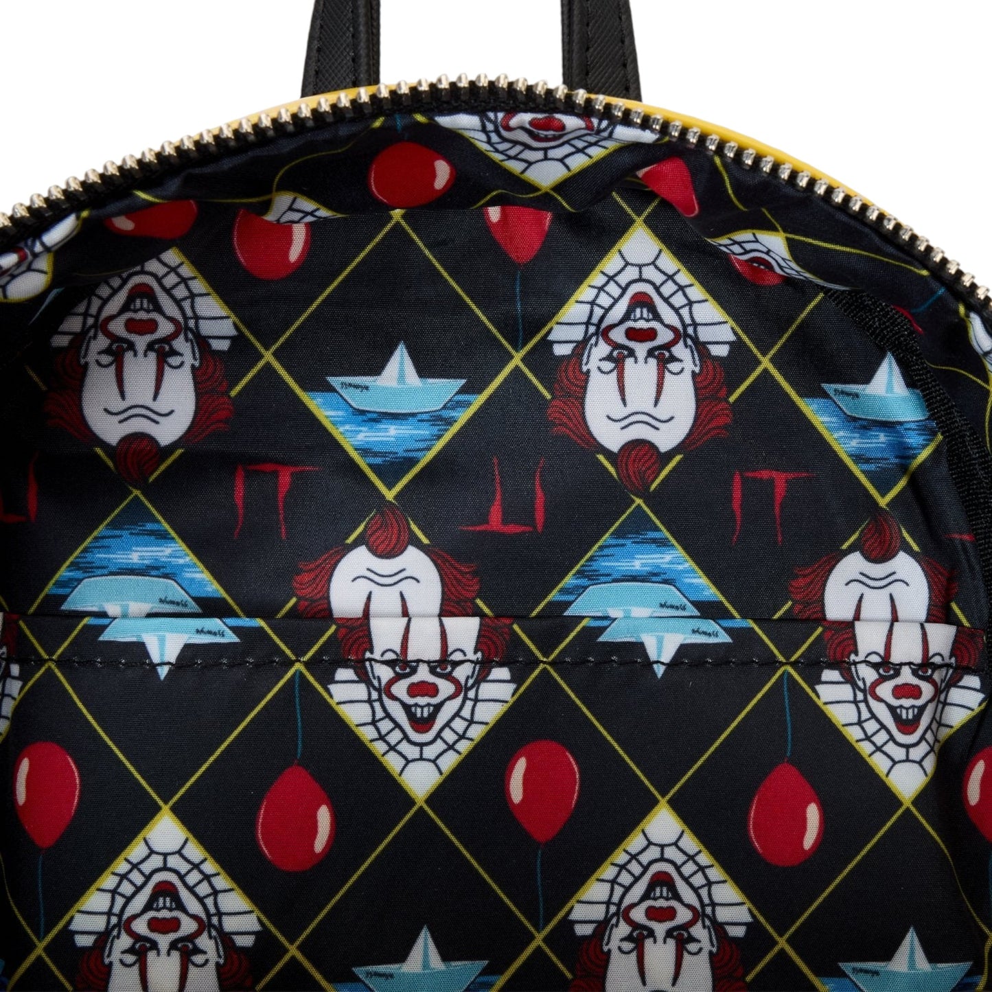 Inside Yellow Loungefly Warner Brothers IT Pennywise Raincoat Cosplay Glow Mini Backpack with a pattern of Pennywise faces and red balloons on a black background
