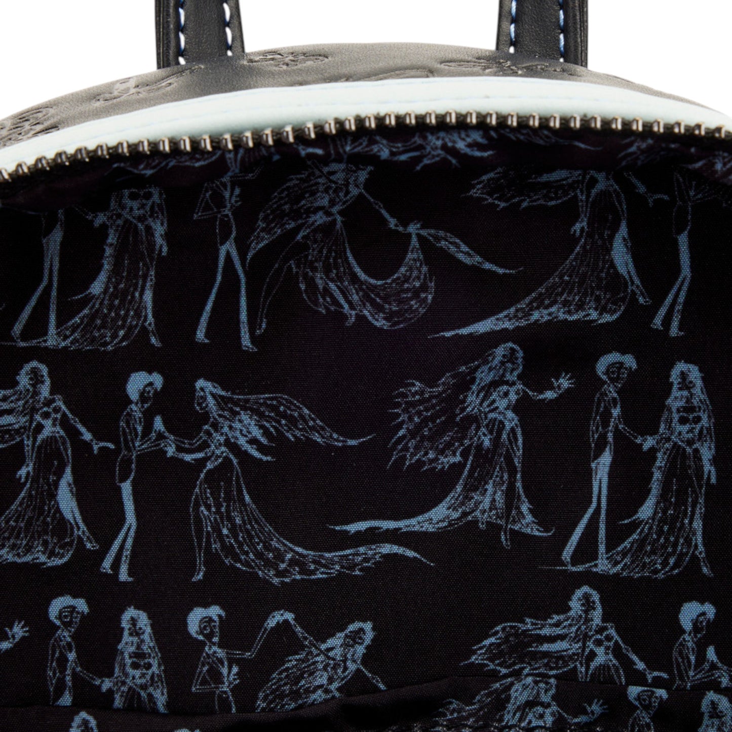 Close-up of the inside of the Corpse Bride Emily Bouquet Mini Backpack with a black and white pattern of figures and creatures.