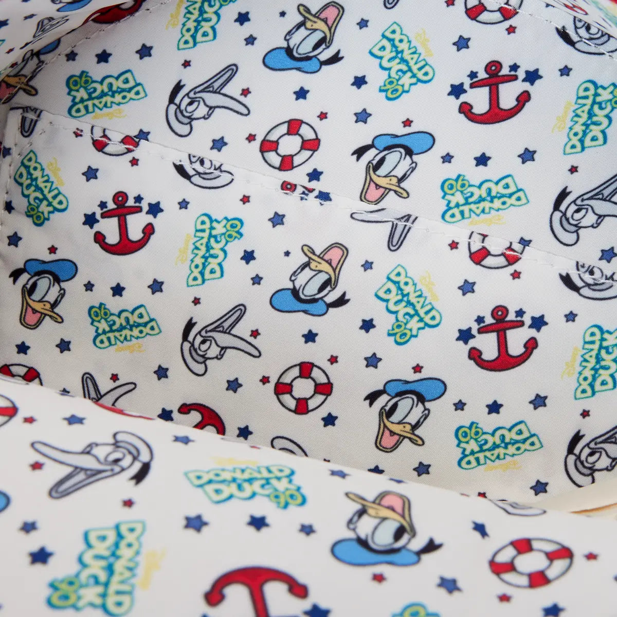 Inside of Round Loungefly Disney Donald Duck 90th Anniversary Lenticular Crossbody Bag with patterned fabric with donald duck characters and nautical elements on a white background
