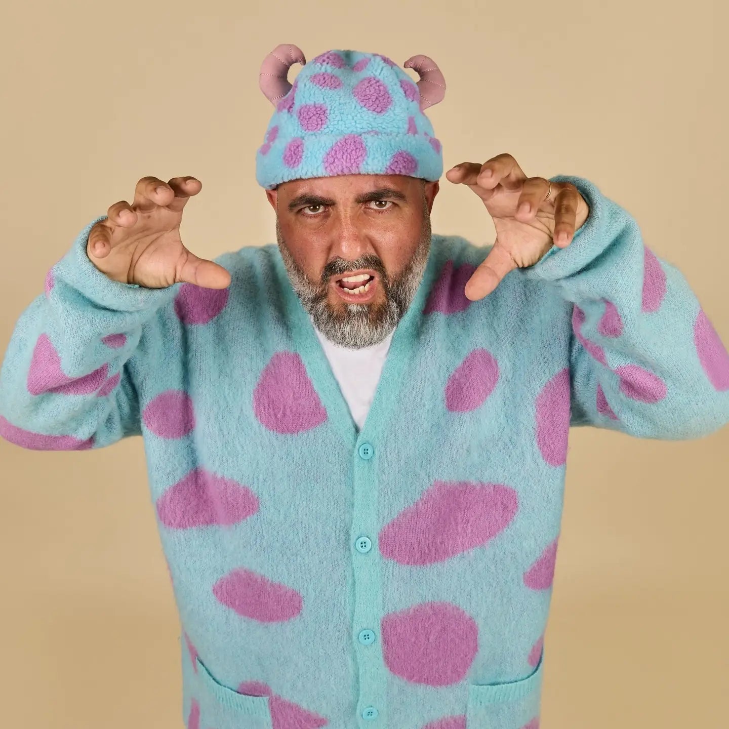 Person wearing a blue and pink polka dot outfit with a matching Sulley Sherpa Beanie on a beige background