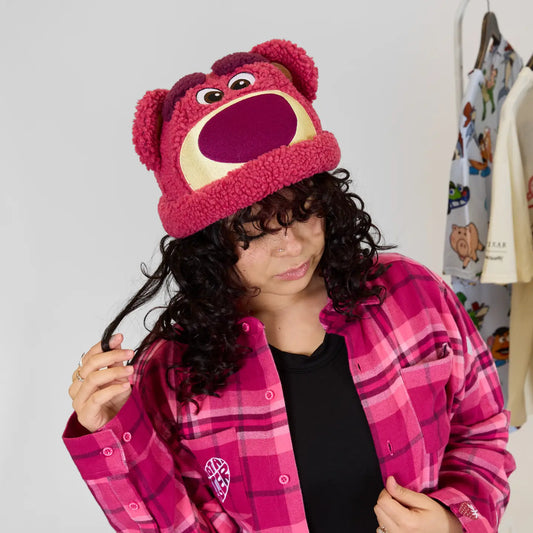 Person wearing a pink plaid jacket and a Toy Story Lotso Sherpa Beanie with a wide mouth.
