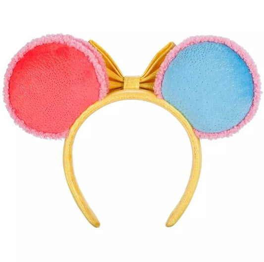 Colorful headband with pink and blue circular "macaron" ends and a yellow bow on a white background
