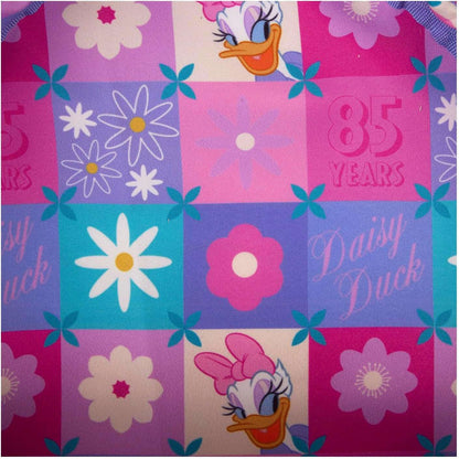 Fabric with Daisy Duck designs and floral patterns on a checkered background.