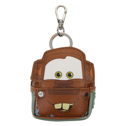 A small brown Mater-themed keychain pouch with a silver clasp, featuring a cartoon face with green eyes and a smile on a white background.