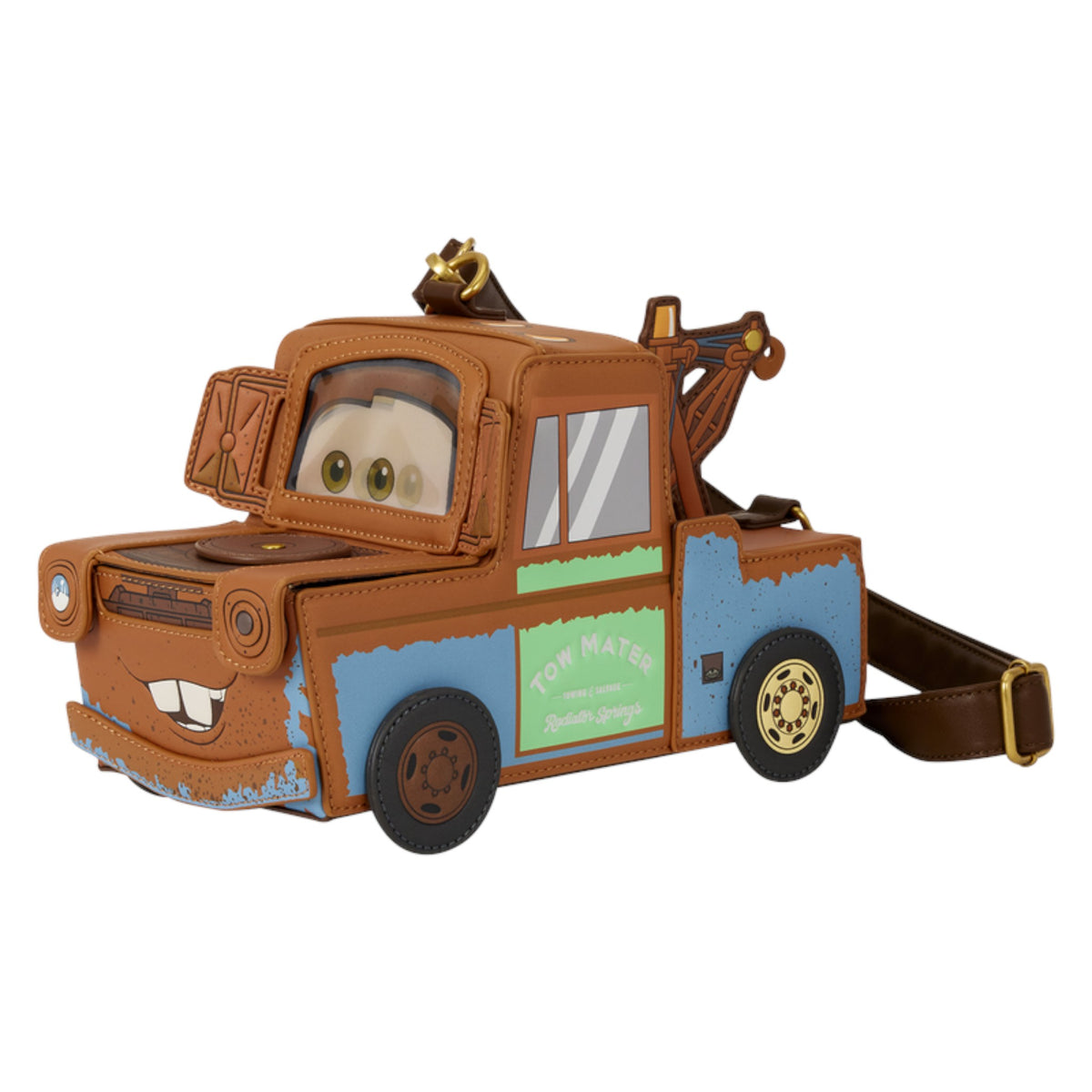 A character-shaped crossbody bag designed like the tow truck Mater from Disney's Cars, featuring a brown faux-leather body, blue side panels, a green 'TOW MATE' side panel, and a brown shoulder strap with a gold buckle, shown on a plain white background.