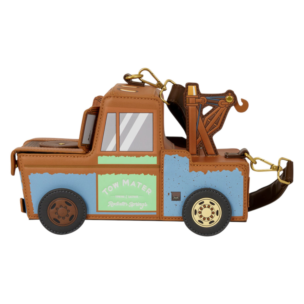 A small tow truck-shaped accessory or bag with a brown body, light blue lower section, green side panel, black wheels, and gold-tone hardware, shown on a plain white background.