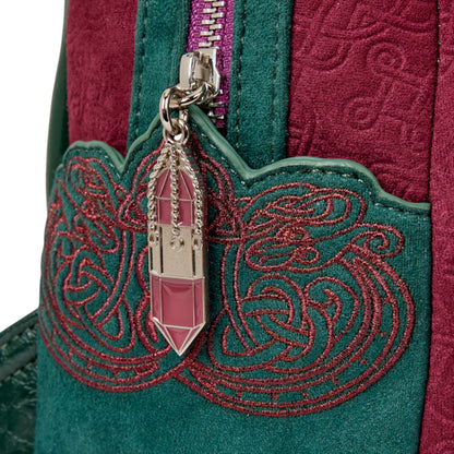 Close-up of a green embroidered bag with a pink crystal zipper charm on a white background