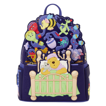A Disney Winnie the Pooh themed backpack featuring Pooh in bed with a teddy bear on the front, with a large, whimsical collage of characters and objects on the back, set against a plain white background.