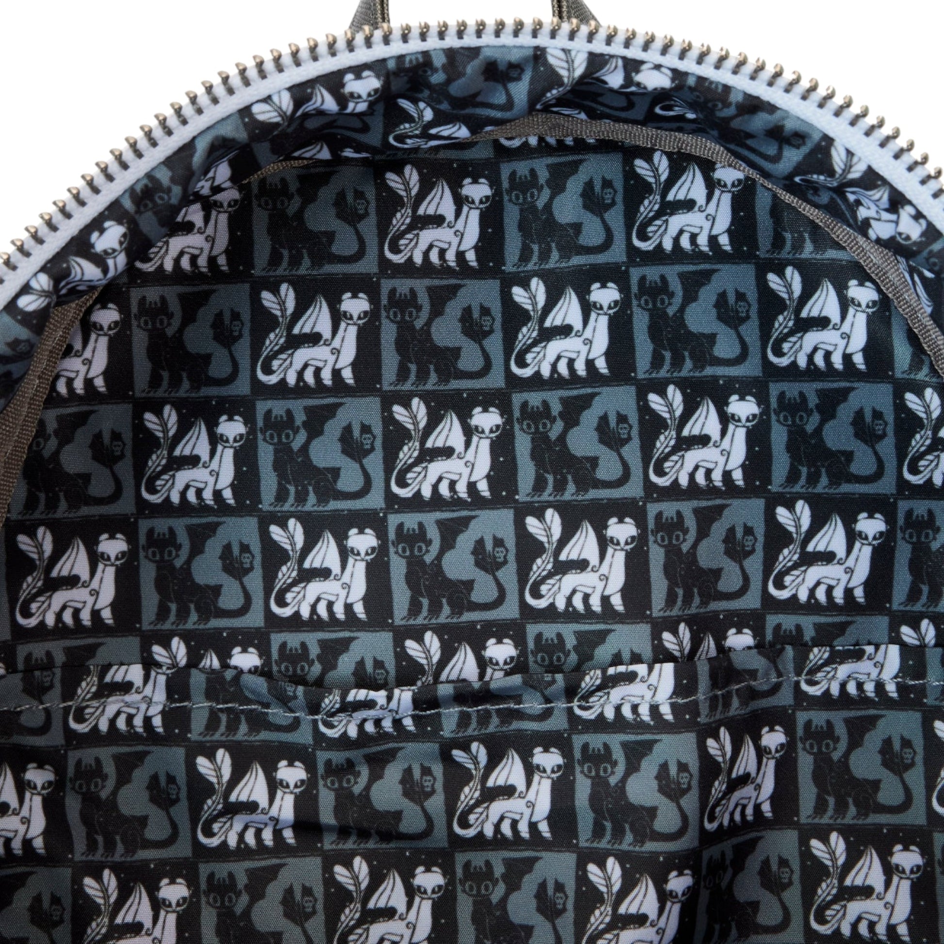 Close-up of a bag with a pattern of Light and Night Fury dragons on a dark background.
