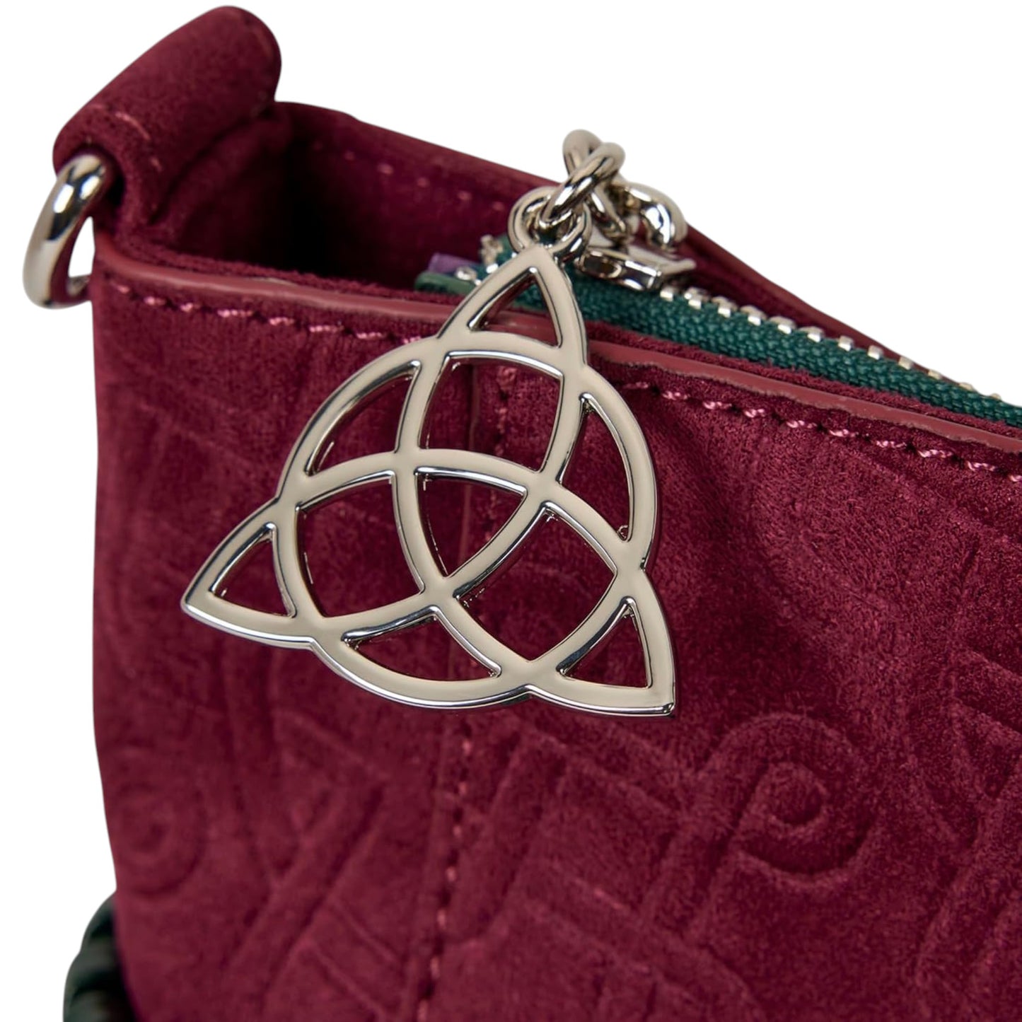 Close-up of Red and green Charmed Power of Three Convertible Backpack & Tote Crossbody Bag with a silver Trinity pendant zipper charm on a white background