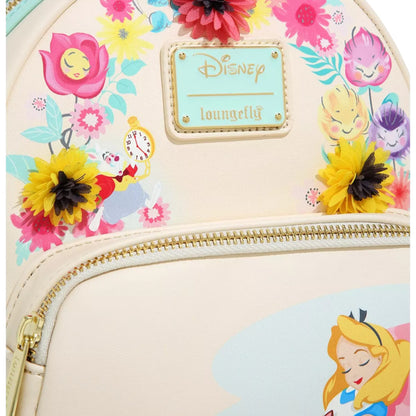 Close-up of Alice in Wonderland Garden Flowers Mini Backpack with Alice character design laying against a mushroom with floral elements and a Disney Loungefly branded logo on a white background