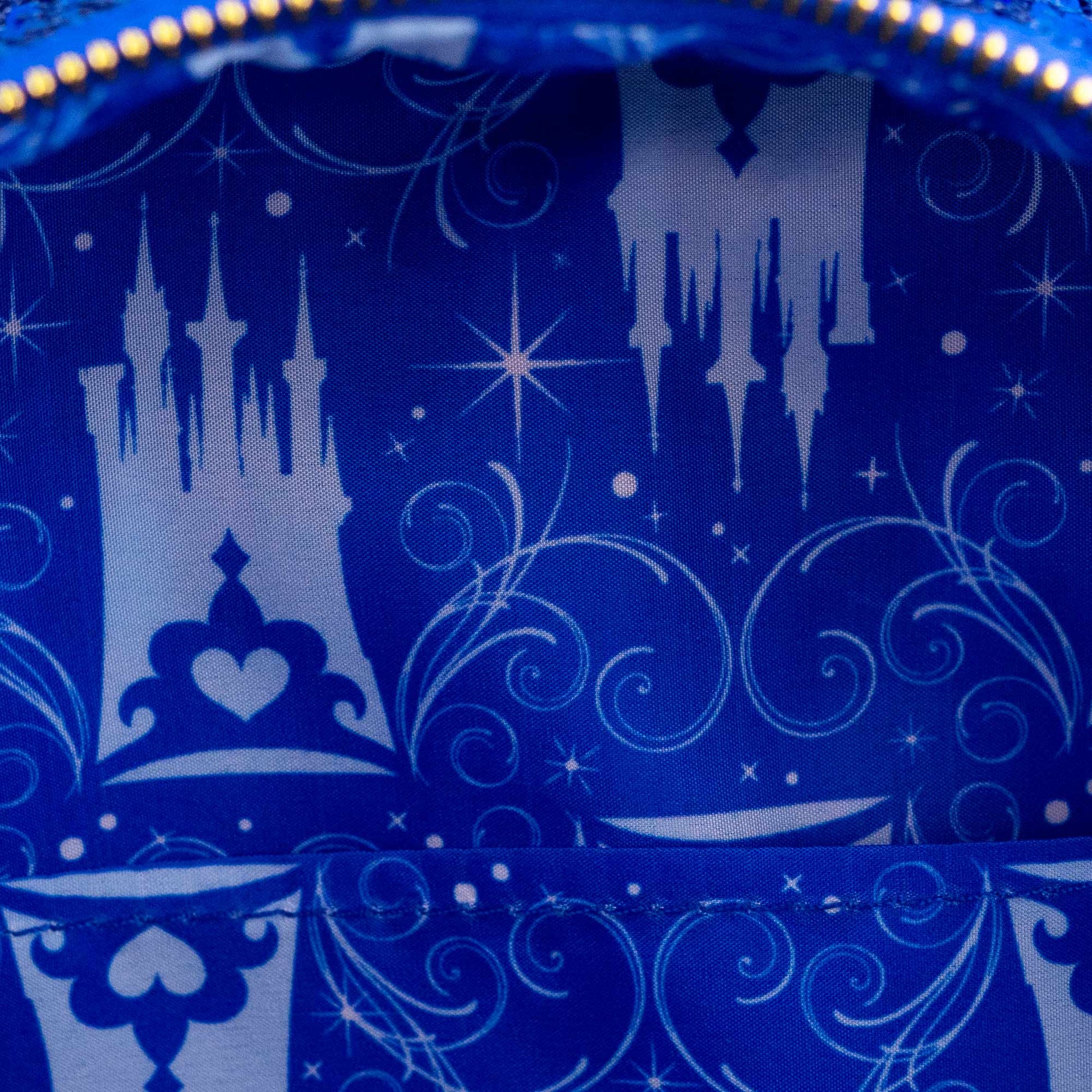 Close-up of inside of Loungefly Disney Cinderella Castle Snow Globe Sequin Mini Backpack with Cinderella Castle patterns on a blue background