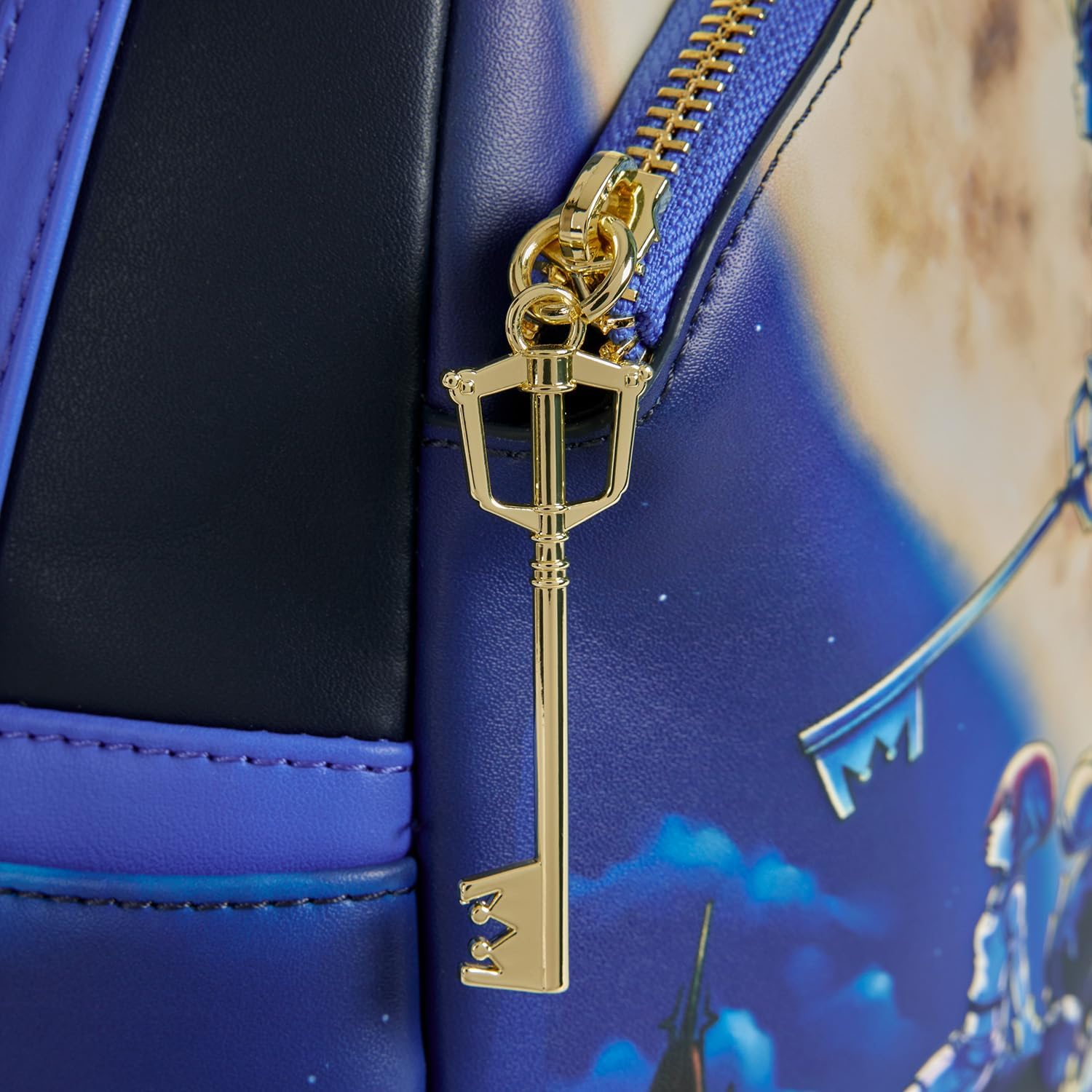 Gold key-shaped zipper pull on a blue Kingdom Hearts Mickey Mini Backpack with a character design.
