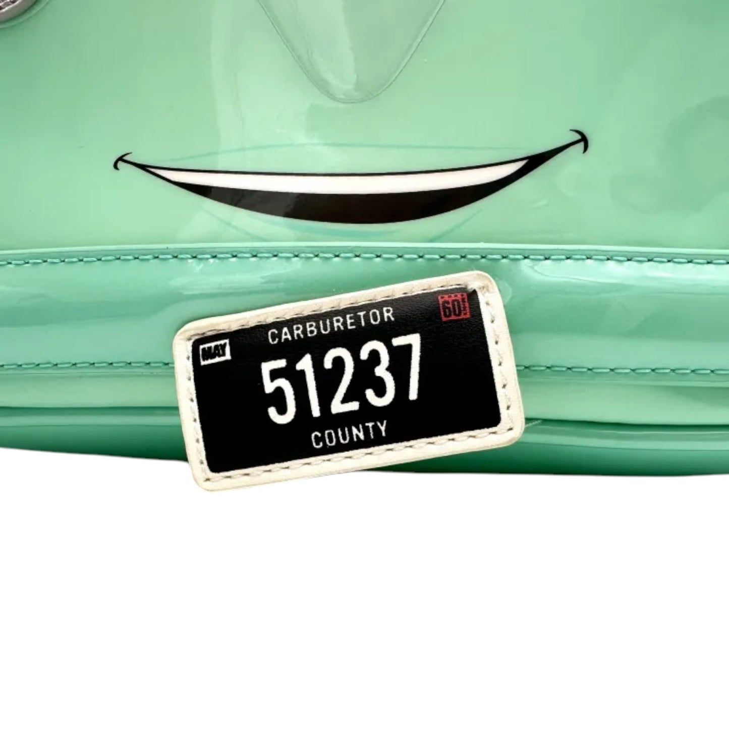 Close-up of Teal Loungefly Disney Pixar Cars Fillmore Mini Backpack with license plate with numbers on a green background