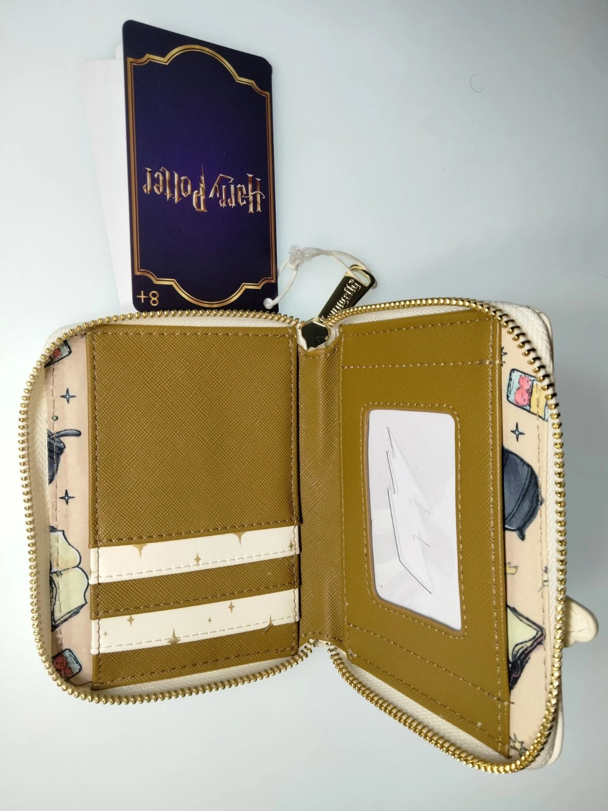 Open Harry Potter Spell Book Hogwarts Castle Zip Wallet with visible interior and card holder on a light gray background