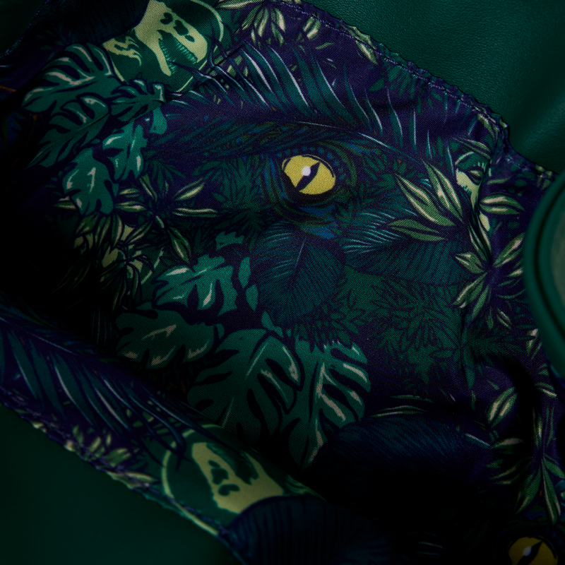 Close-up of inside of Loungefly New Jurassic World Jungle Velociraptor Glow Drawstring Mini Backpack with leaf foliage and eye pattern