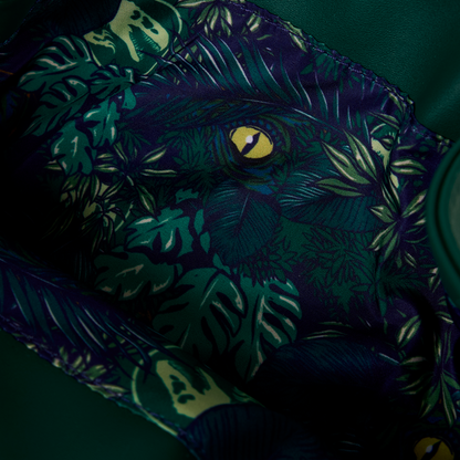 Close-up of inside of Loungefly New Jurassic World Jungle Velociraptor Glow Drawstring Mini Backpack with leaf foliage and eye pattern