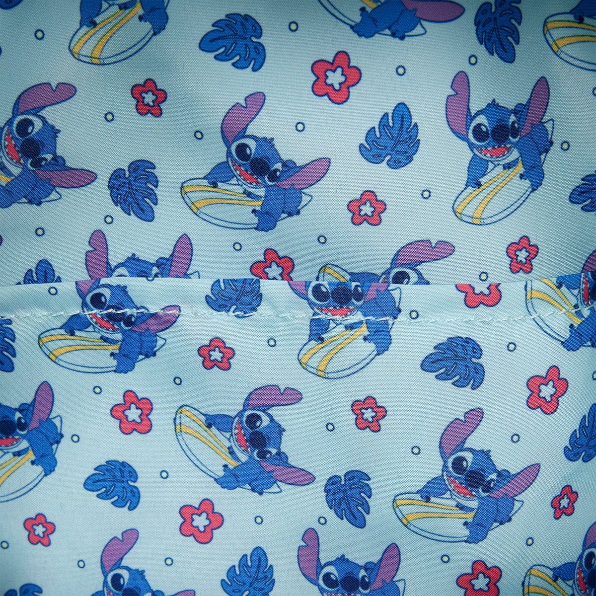 Patterned fabric with Stitch character on a light blue background