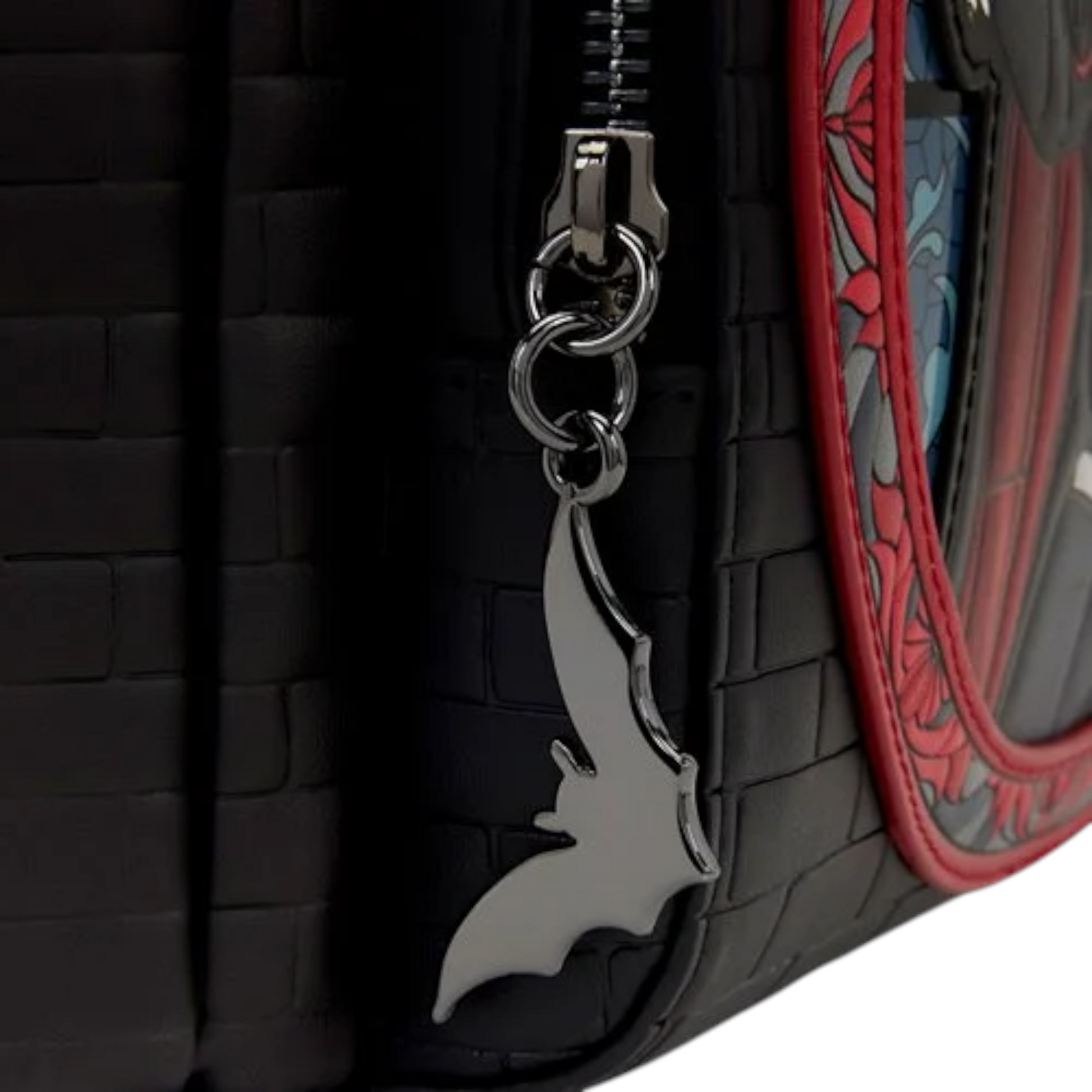 Close-up of Loungefly Universal Monsters Dracula Stained Glass Mini Backpack with a silver bat zipper charm 