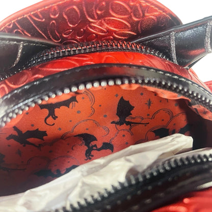 Close-up of a Red Dragon Mini Backpack with black dragon designs.
