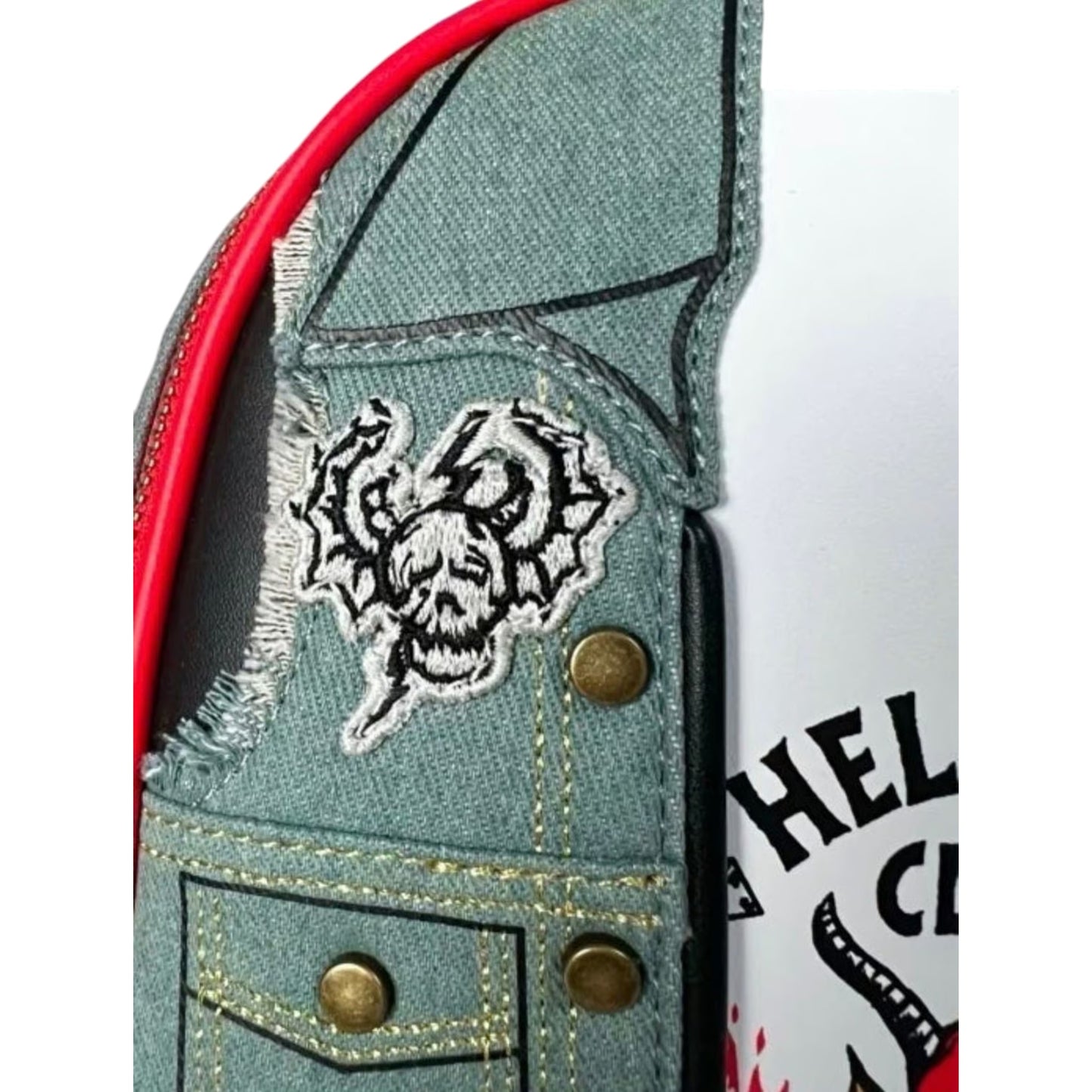 Close-up of Loungefly Stranger Things Eddie Munson Hellfire Club Cosplay Mini Backpack with a patch and a visible Hellfire Club logo.