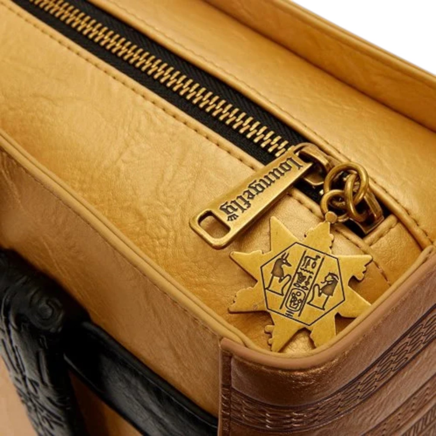 Close-up of The Mummy Book of the Living Mid-Size Backpack with Egyptian hieroglyphics and symbols on a gold zipper charm and emblem.