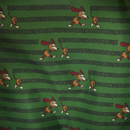 Close-up of inside Loungefly Toy Story Slinky Dog Cosplay Mini Backpack with Slinky Dog character pattern on a green background