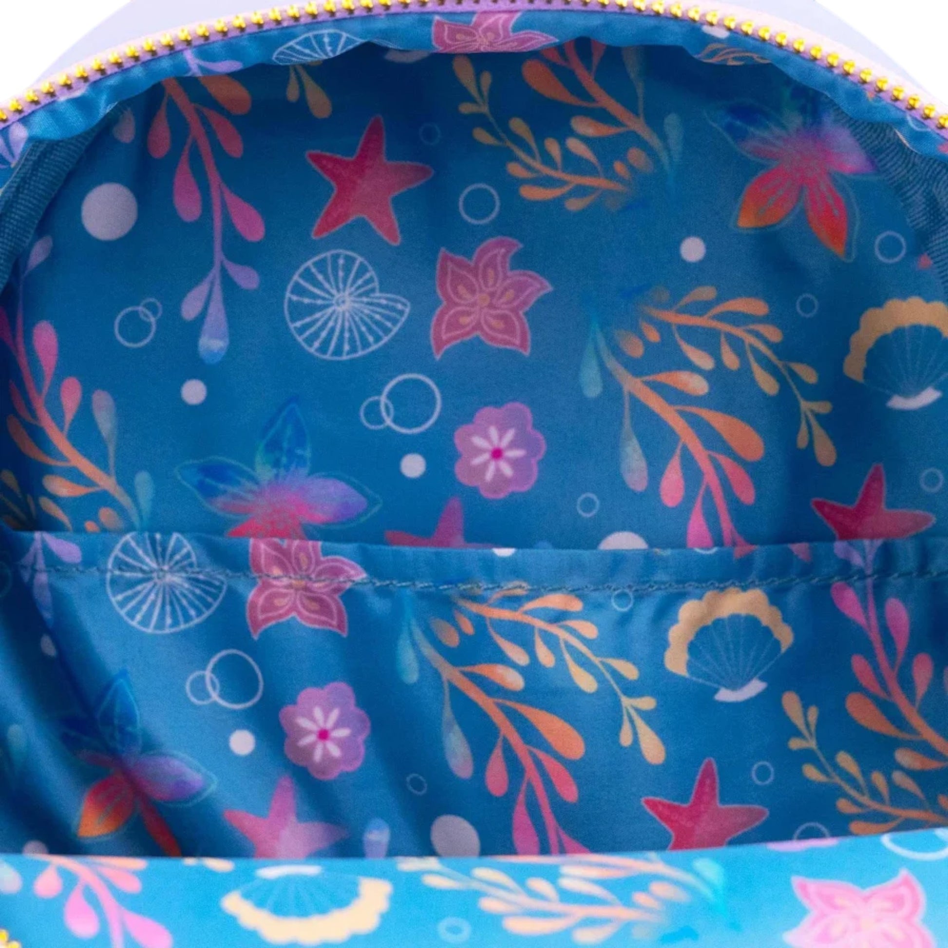 Close-up of inside of Loungefly Disney The Little Mermaid Ariel Soft Floral Mini Backpack with starfish and plant patterns on a blue background