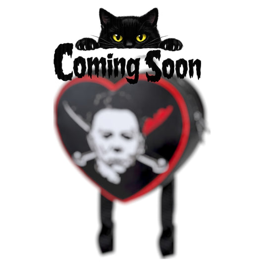 Michael Myers backpack with a cat sitting on "Coming Soon" text on a white background