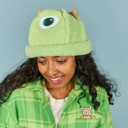 Person wearing a Mike Wazowski Sherpa Beanie with one eye design against a light blue background