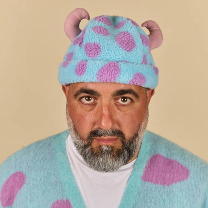 Person wearing a Sulley Sherpa Beanie with animal ears on a beige background