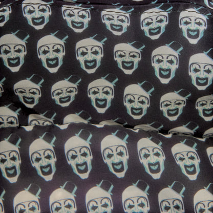 Close-up of a fabric surface with a repeating print of stylized clown faces in white and pale blue on a very dark charcoal background.