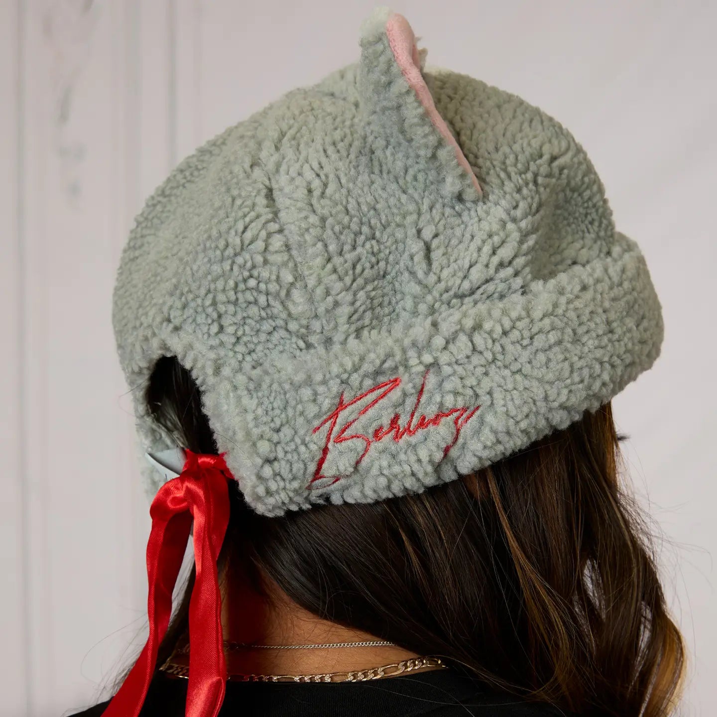 Light grey The Aristocats Berloiz Sherpa Beanie with red ribbon and on a plain background