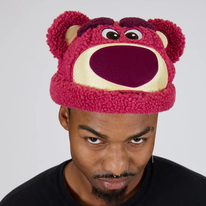 Person wearing a pink bear-themed Toy Story Lotso Sherpa Beanie against a gray background