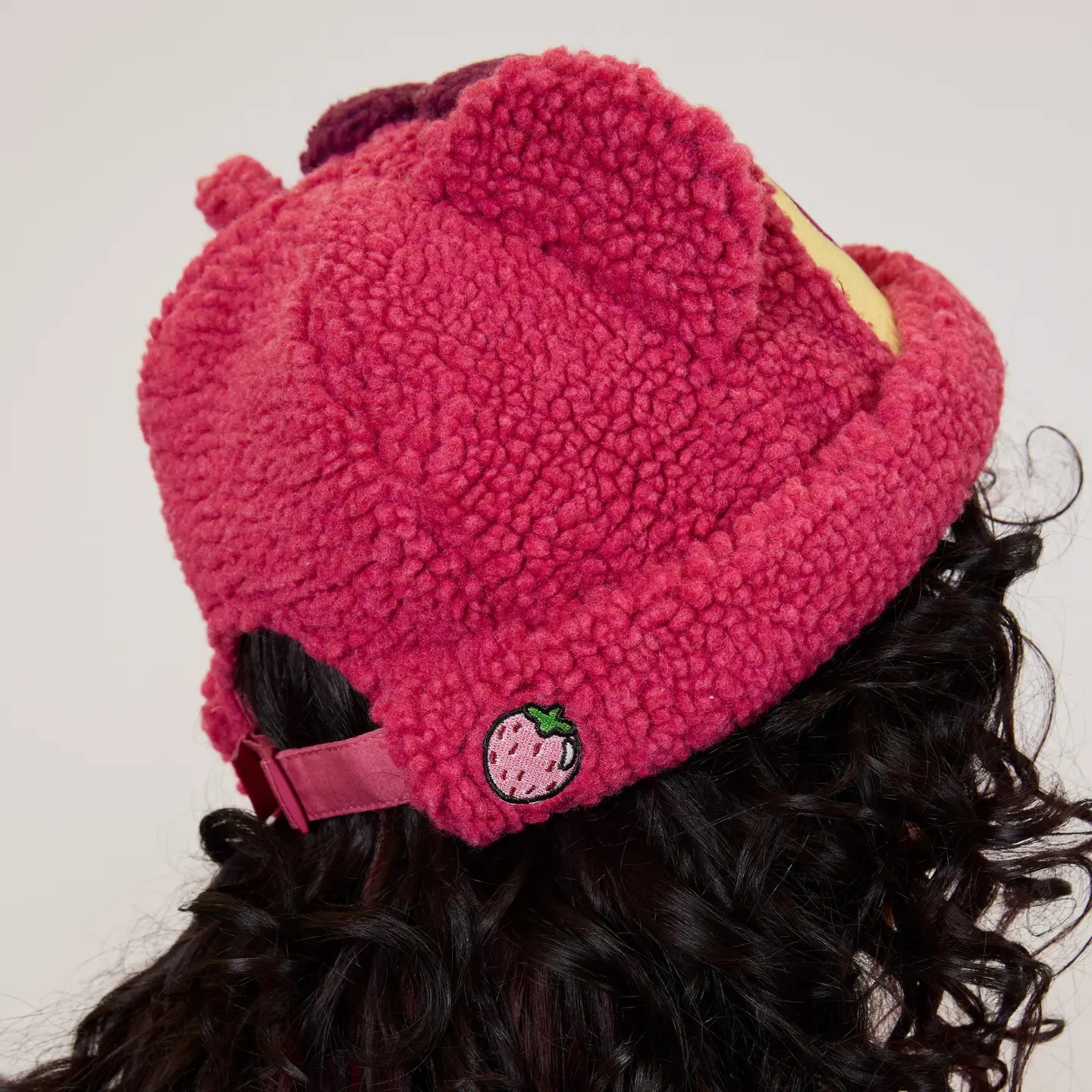 Pink Toy Story Lotso Sherpa Beanie with a small logo on a person wearing it.