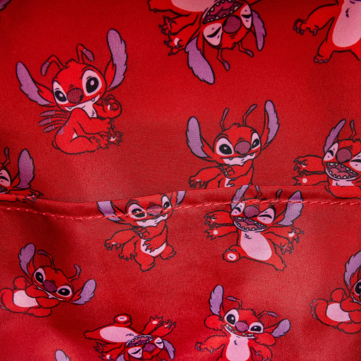 Close-up of inside of Red Loungefly Lilo & Stitch Leroy Cosplay Mini Backpack with Leroy character fabric pattern on a red background