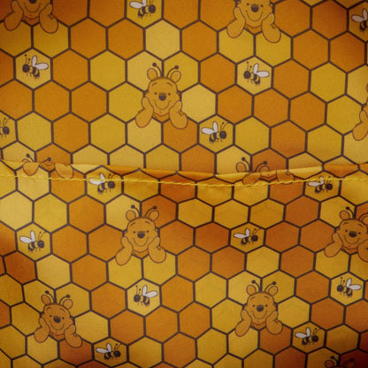 Fabric with honeycomb pattern featuring winnie the pooh and bees on a yellow background