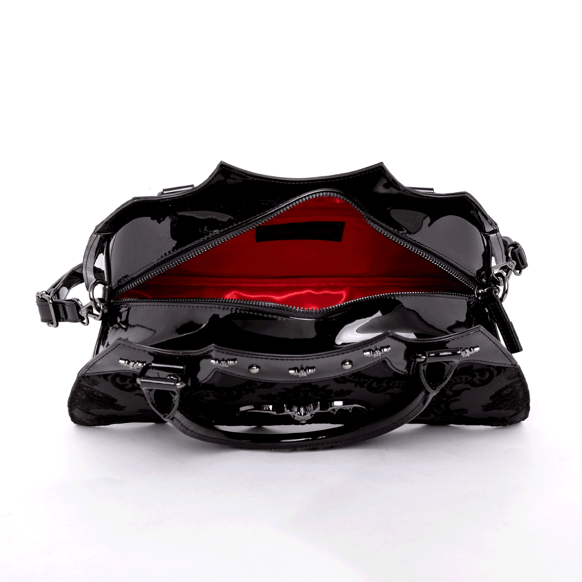 Top view of opened black bat shaped bag with red interior on a white background