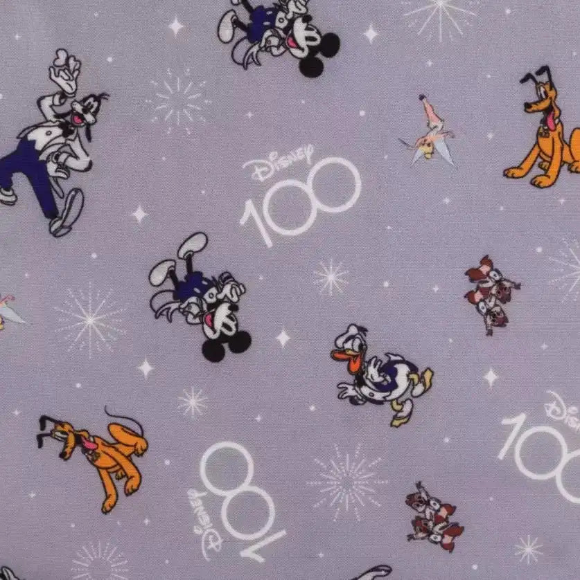 Disney-themed fabric with mickey and friends characters and 'Disney 100' text on a gray background