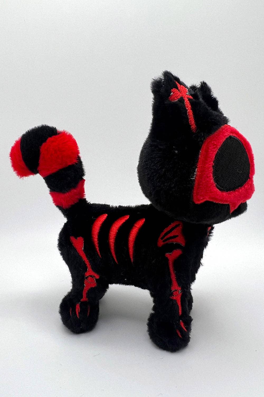 Black and red plush cat on a white background