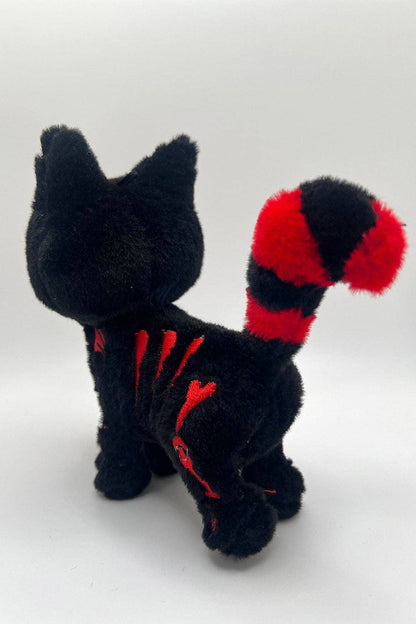 Black plush toy cat red accents on a white background